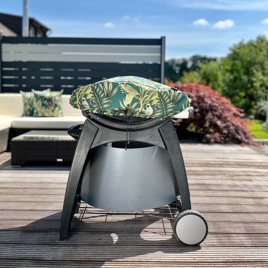 Weber Tischgrill auf Terrasse mit bunter Grillhaube Affen-Design